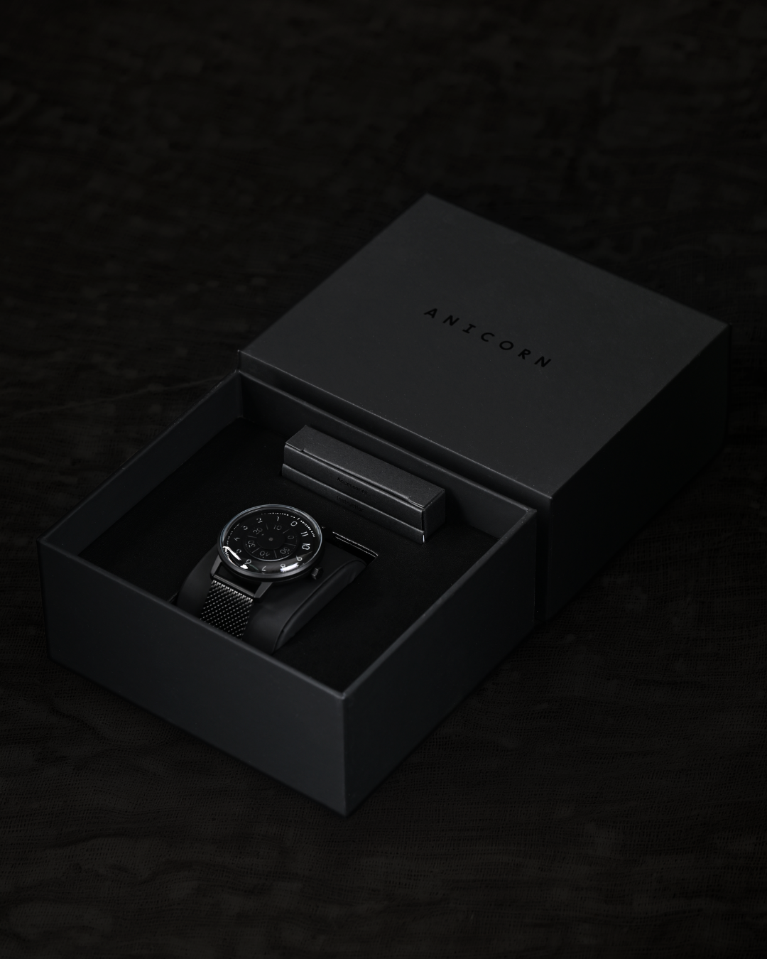 Anicorn K452 Nemesis watch displayed inside a black Anicorn presentation box with matching accessories.