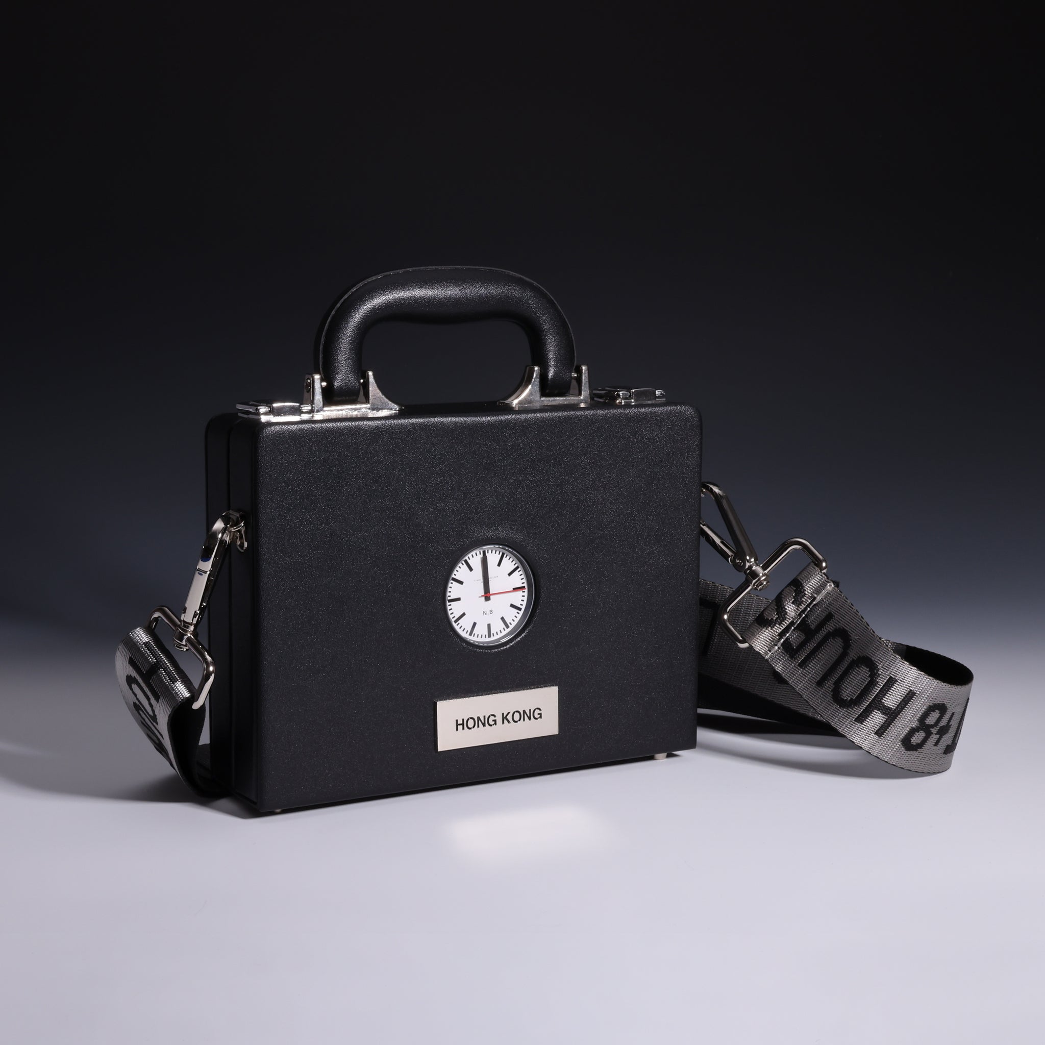 Showcasing the TTT - The Time Traveler Watch and the bag by Nik Bentel Studio in its entirety, set against a black upper background and a grey bottom background.