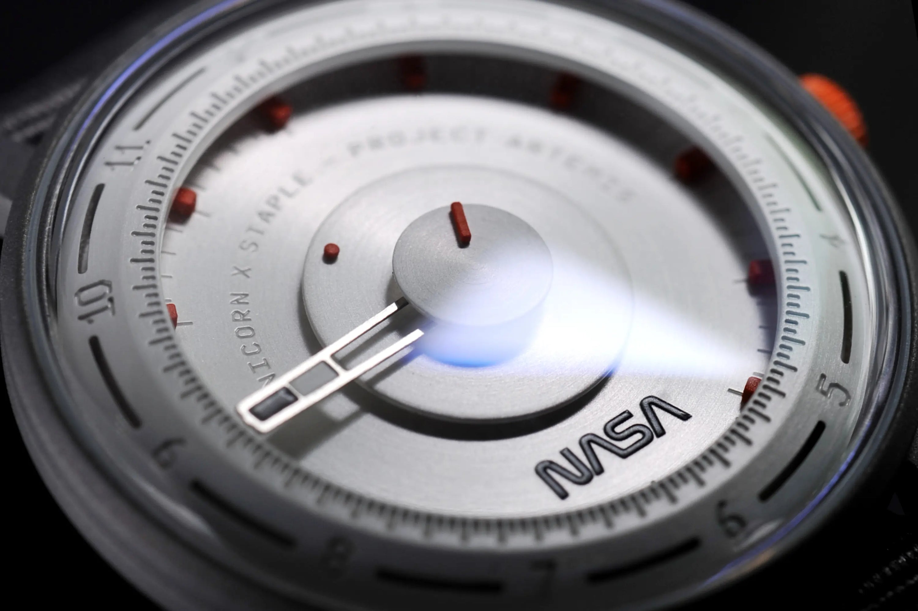 Artemis Time has a clean, minimal and sleek design, the gray color is inspired by the moon rock, with the orange highlights on the dial and crown recalling the “International Orange” applied on the spacesuit. 