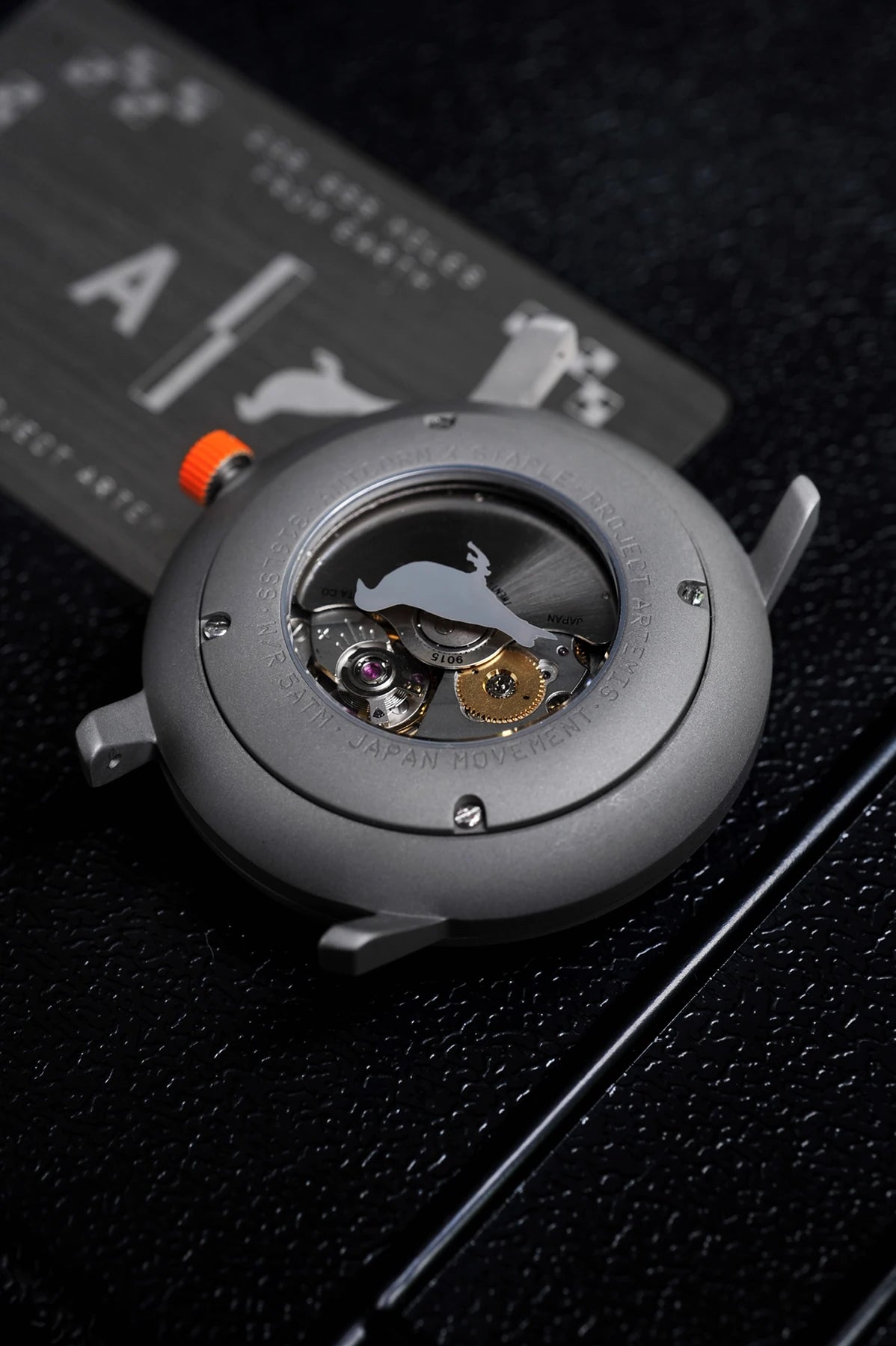 Artemis Time has a clean, minimal and sleek design, the gray color is inspired by the moon rock, with the orange highlights on the dial and crown recalling the “International Orange” applied on the spacesuit, back case
