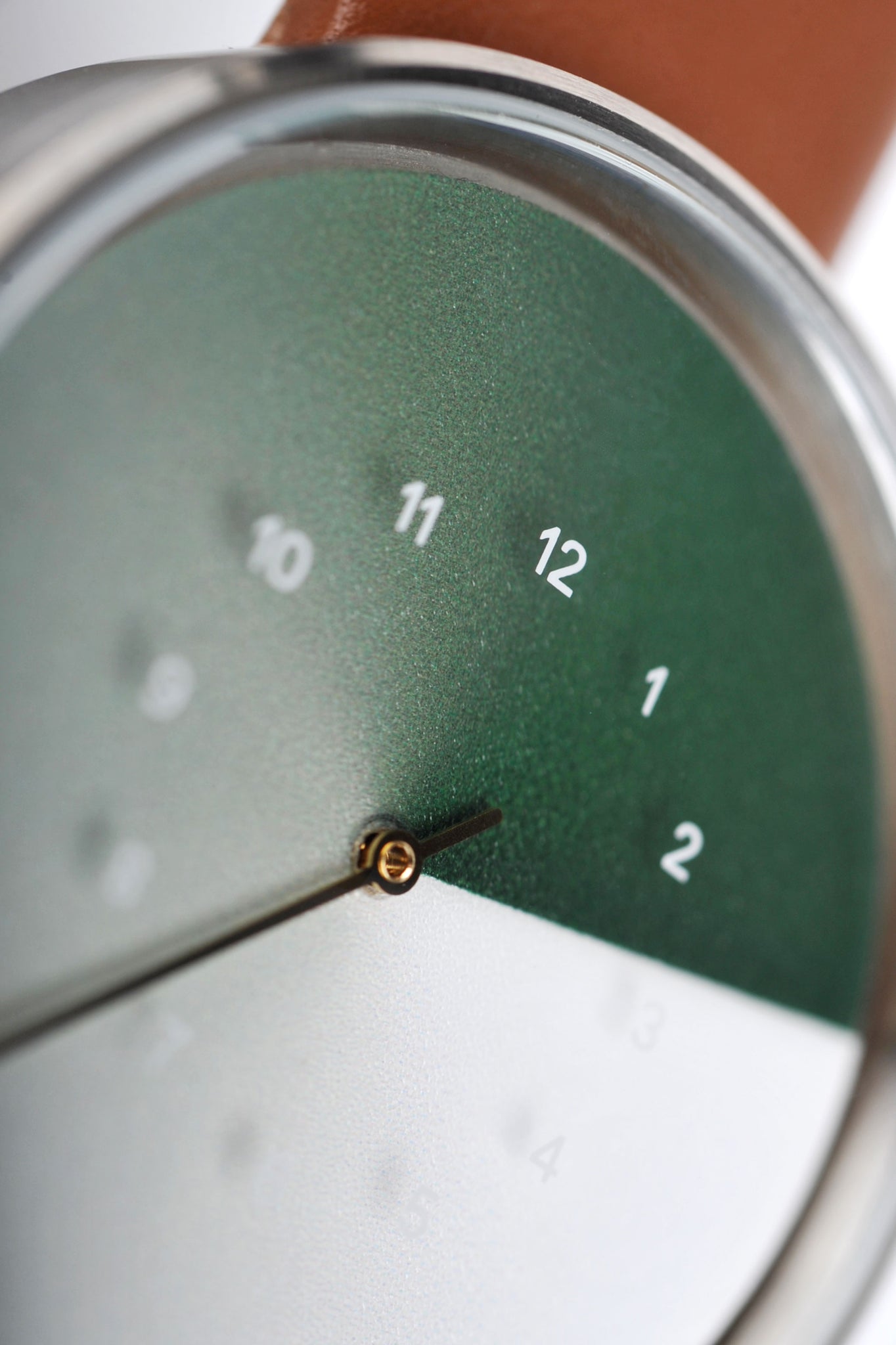 This is a close-up shot of the TTT#1 Seoul Hidden Time Watch in Olive. The image showcases the intricate details and sleek green watch face of this high-quality timepiece